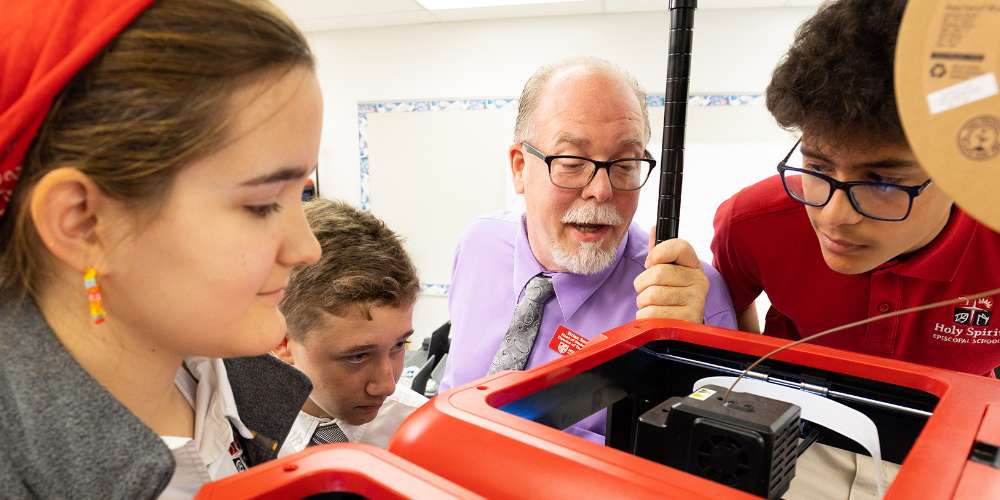 Robotics teacher instructing a group of students